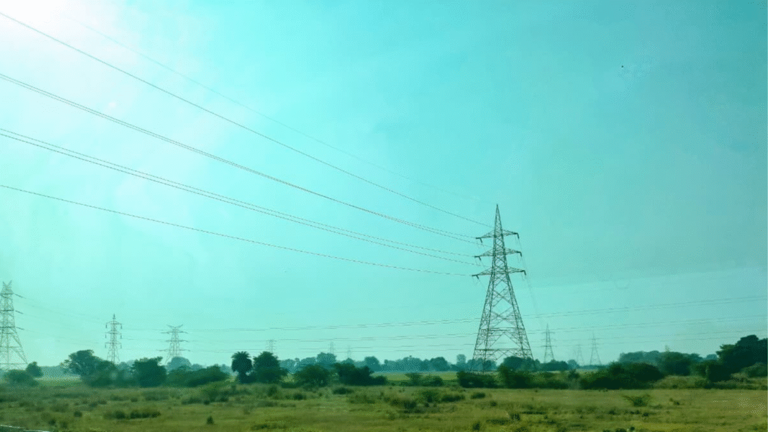 High-voltage electricity transmission towers and power lines running across an open landscape.