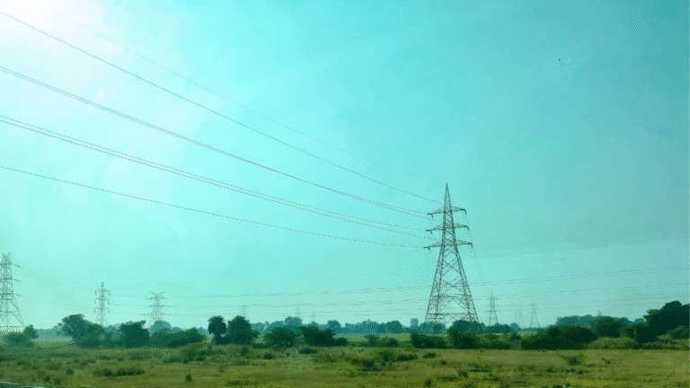 High-voltage electricity transmission towers and power lines running across an open landscape.
