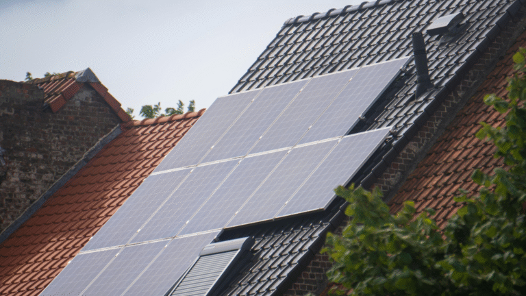 Solar panels installed on the sloped roof of a residential house with tiled roofing.