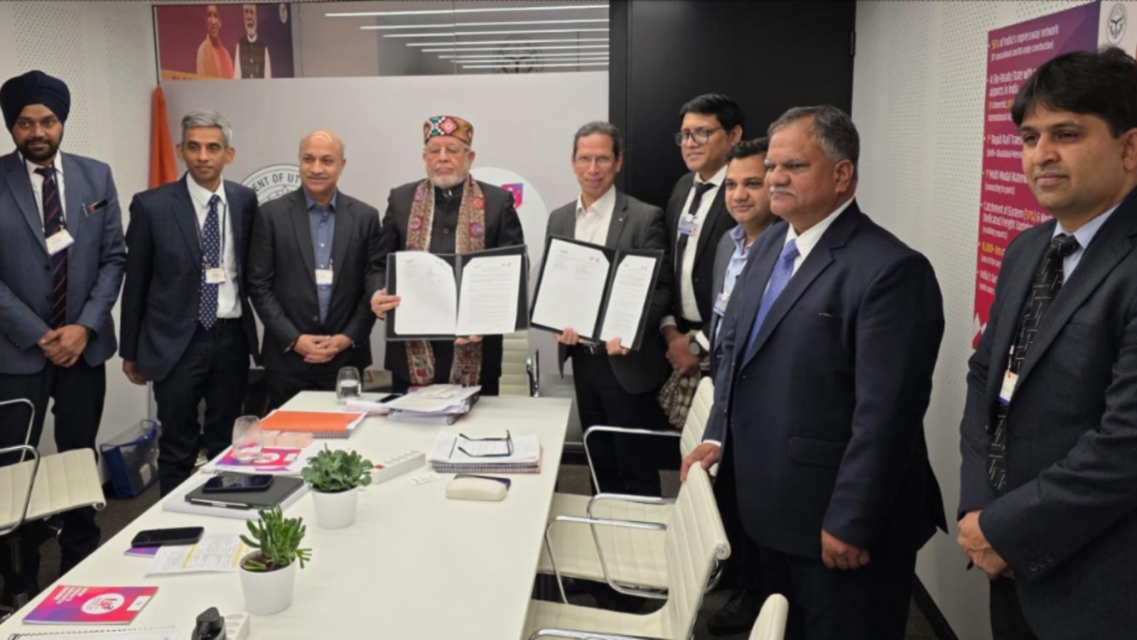 Representatives from NTPC Green Energy and the Government of Uttar Pradesh pose after signing a memorandum of understanding for renewable energy and green hydrogen projects, with signed documents displayed at the World Economic Forum meeting in Davos.