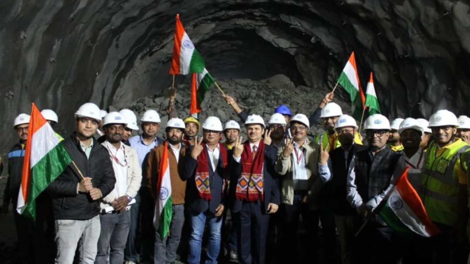 NHPC officials and engineers inside Diversion Tunnel-3 at the 2,880 MW Dibang Multipurpose Project after the February 17, 2026 breakthrough, holding Indian flags and wearing safety helmets.