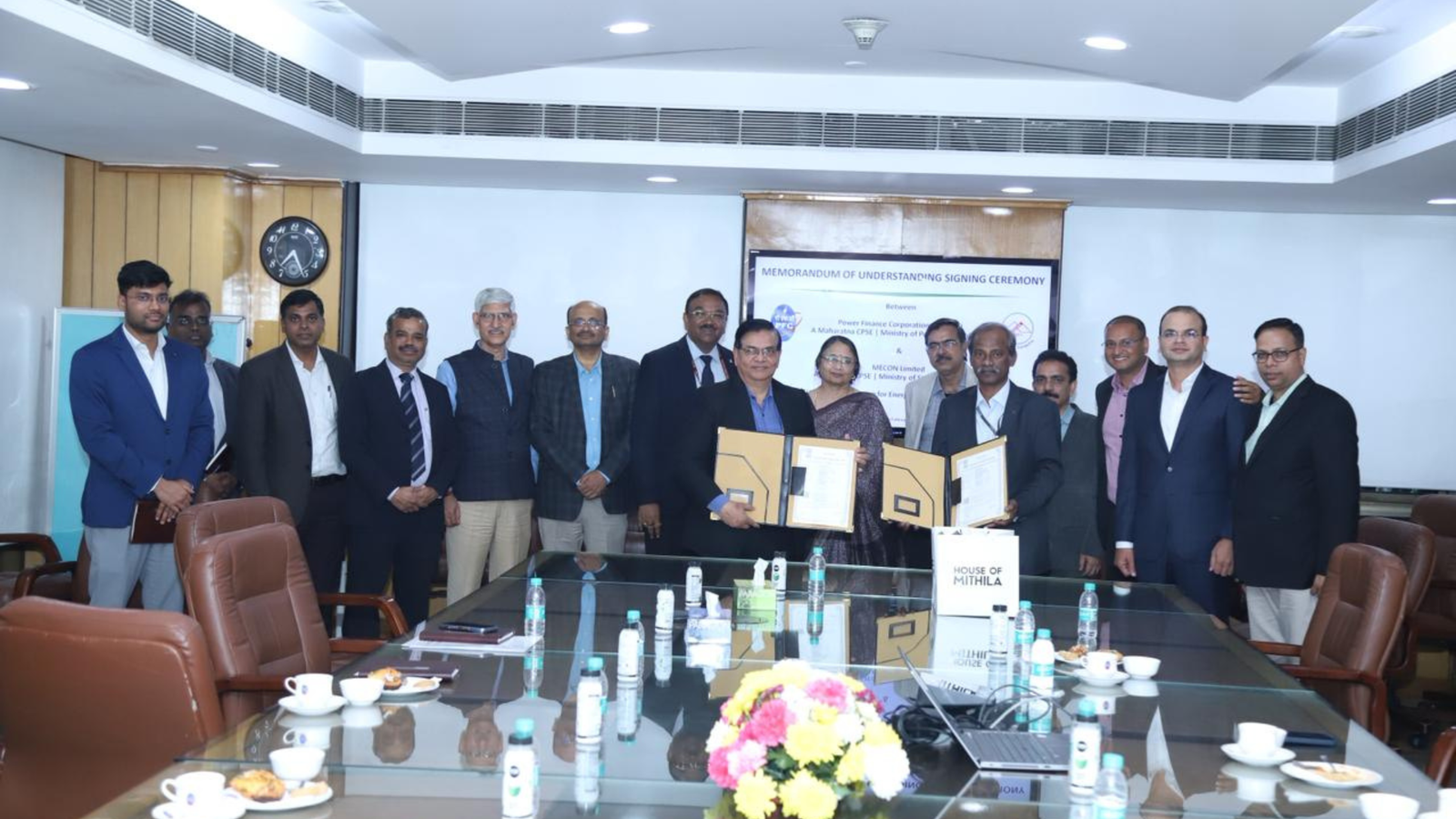 Senior officials of Power Finance Corporation Limited and MECON Limited during the Memorandum of Understanding signing ceremony, holding signed documents in a conference room.