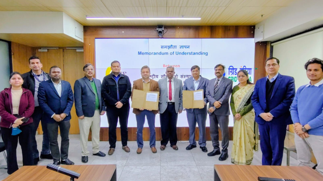 Officials from the National Institute of Solar Energy and Grid Controller of India Limited pose after signing a Memorandum of Understanding on day ahead and intra day solar power forecasting, with signed documents displayed at the event.