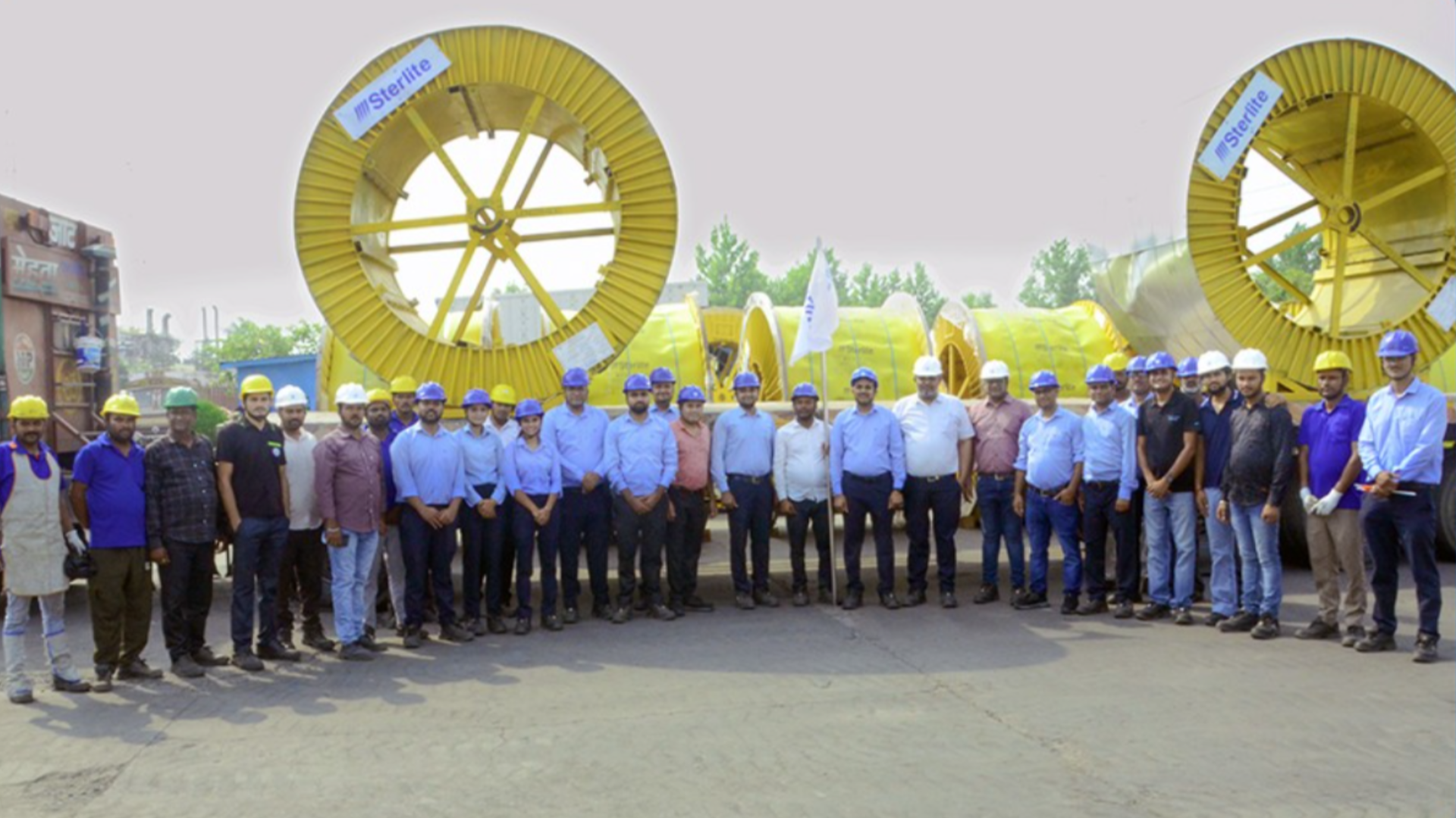 Sterlite Electric team members stand beside large cable drums carrying 220 kV XLPE-insulated power cables during the flag-off of the company's first export shipment to Sri Lanka for a transmission substation project in Colombo.