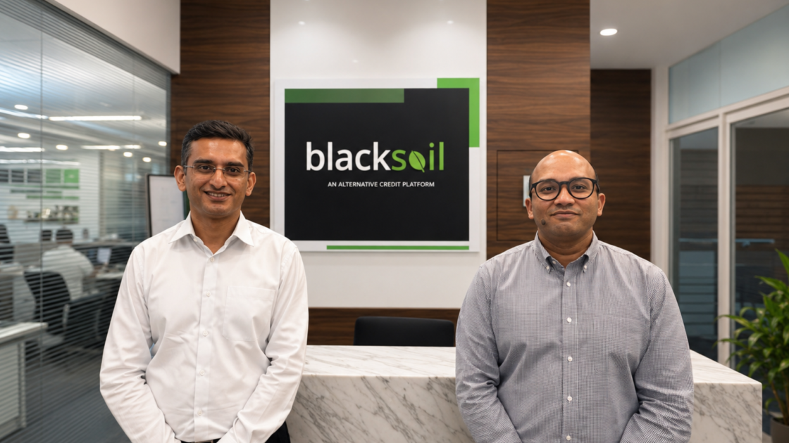 BlackSoil executives Ankur Bansal (left) and Aditya Damani (right) stand in the company's office reception area in front of a BlackSoil logo, following the acquisition of Credit Fair's solar financing business.
